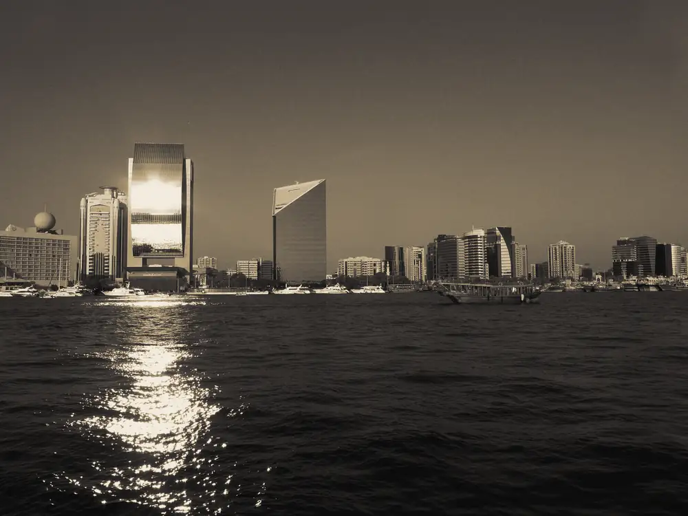 Dubai Creek, with towers along the water and a traditional dhow